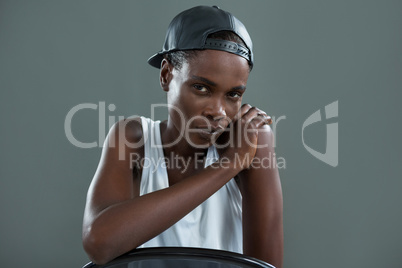 Androgynous man in cap looking at camera