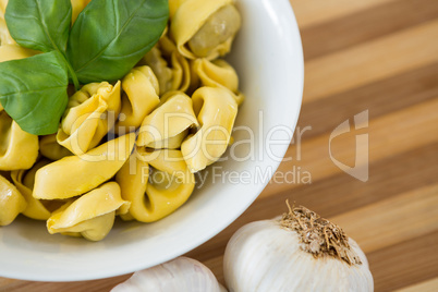 Overhead view of pasta served in bowl on cutting board