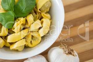 Overhead view of pasta served in bowl on cutting board