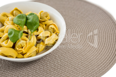 High angle view of cooked pasta served in bowl on place mat