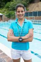 Portrait of smiling female coach standing with arms crossed