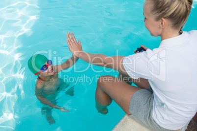 Female trainer giving high five to boy