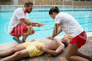 Lifeguards pressing chest of unconscious senior man