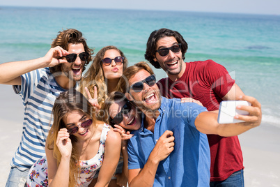 Young friends taking selfie at beach