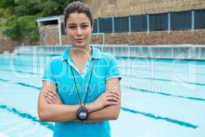 Portrait of female coach standing with arms crossed