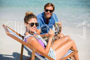 Smiling young couple at beach during sunny day
