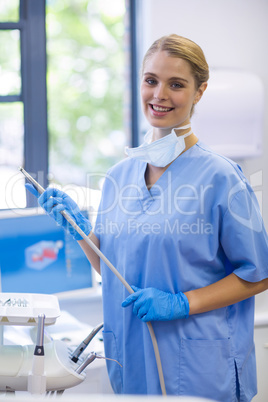 Portrait of female nurse holding dental tool