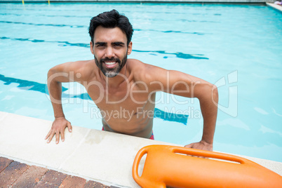Smiling man standing in swimming pool