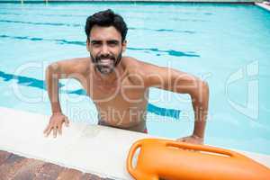 Smiling man standing in swimming pool