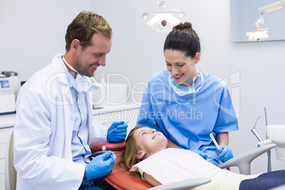 Smiling dentists interacting with young patient