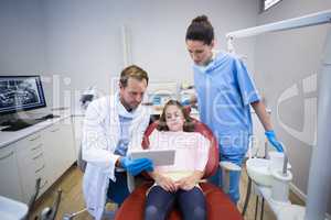 Dentists showing digital tablet to young patient