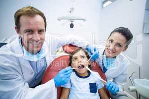 Dentists examining young patient in dental clinic