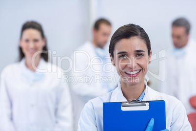 Smiling dentist standing at dental clinic