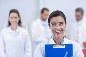 Smiling dentist standing at dental clinic