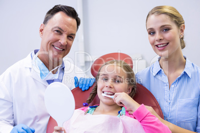 Portrait of dentist with young patient and his mother