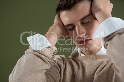 Frustrated androgynous man holding head