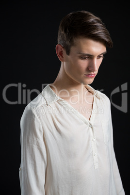 Androgynous man posing against grey background