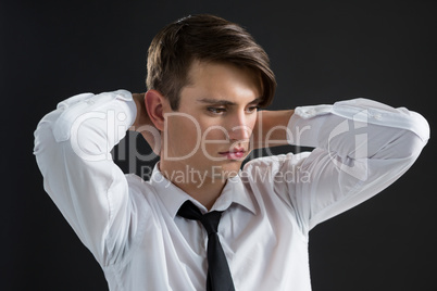 Androgynous man with hands on his neck