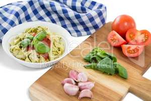Vegetables on cutting board by pasta and napkin