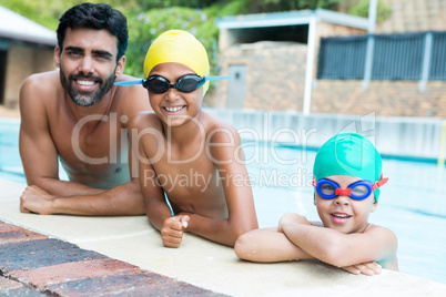 Father and kids smiling in the pool