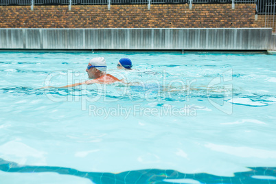 Senior couple swimming in pool