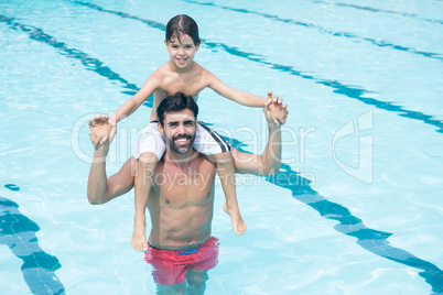 Father carrying son on shoulder in pool