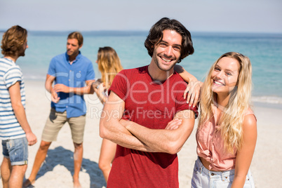 Couple standing by friends on shore at beach