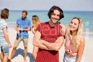 Couple standing by friends on shore at beach