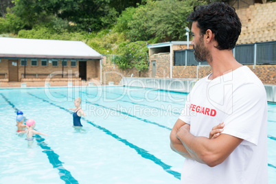 Lifeguard looking at students playing in the pool