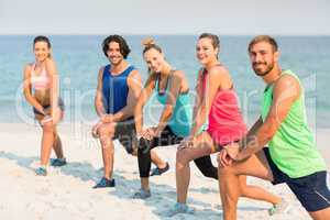 Friends stretching on shore at beach