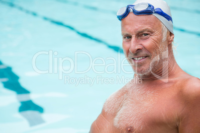 Smiling senior man sitting at poolside