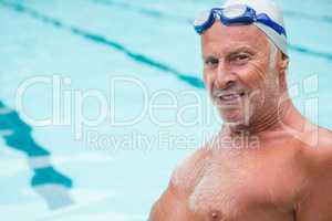 Smiling senior man sitting at poolside