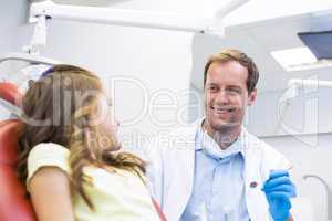 Smiling dentist talking to young patient