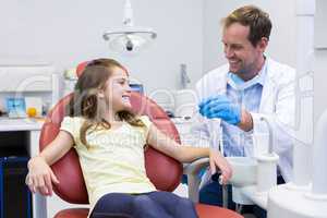 Smiling dentist talking to young patient