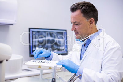 Dentist checking tools in dental clinic