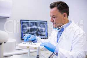 Dentist checking tools in dental clinic