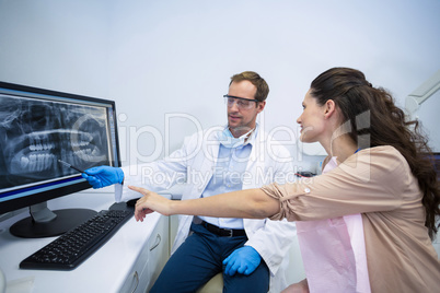 Dentist showing an x-ray of teeth to female patient