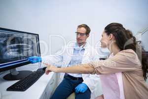 Dentist showing an x-ray of teeth to female patient