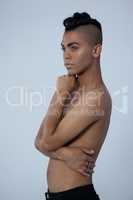Sensuous transgender standing against gray background