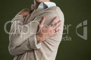 Androgynous man touching his body against green background