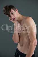 Shirtless androgynous man posing with hand on face