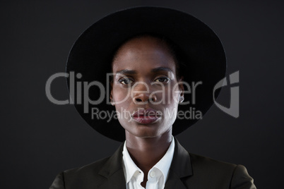 Androgynous man in suit posing against grey background