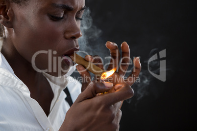 Androgynous man lighting a cigar