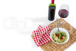 Pasta served in bowl on place mat with wine and napkin