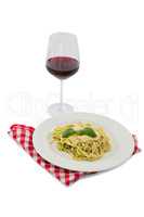 Pasta served in dish by wineglass
