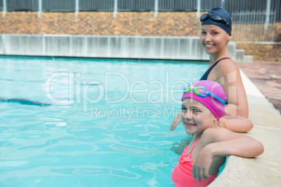 Female instructor and young girl relaxing in pool