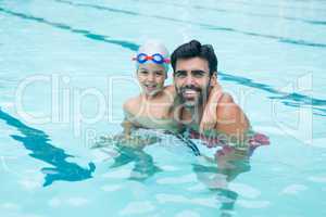 Portrait of father and young boy playing in pool