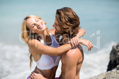 Young couple embracing against sea