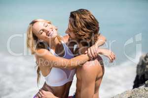 Young couple embracing against sea