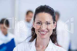 Smiling dentist standing at dental clinic